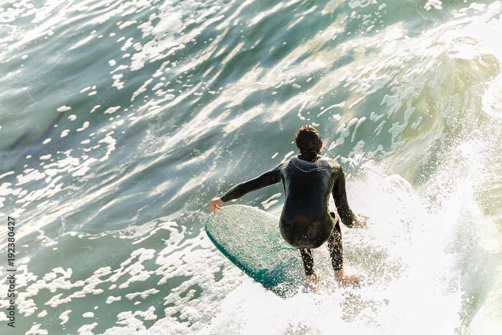 Overhead view of surfer on wave during a beautiful golden sunrise in California Overhead view of surfer on wave during a beautiful golden sunrise in California
