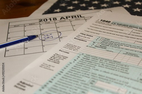 Calendar and form 1040 income tax form for 2017 showing tax day for filing is April 17 2018 photo