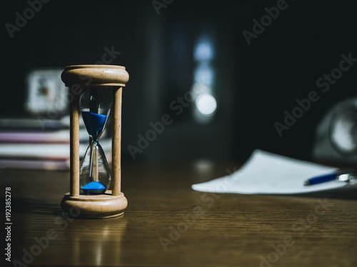 close up of hourglass on the table, blurry background