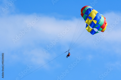 Tourists enjoying parasailing in a blue sky of Roatan, Honduras.
