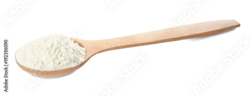 Wooden spoon with wheat flour on white background