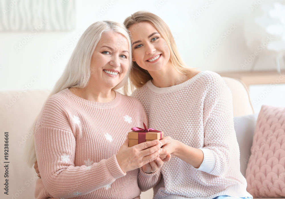Young daughter and mother with gift box at home Young daughter and mother with gift box at home