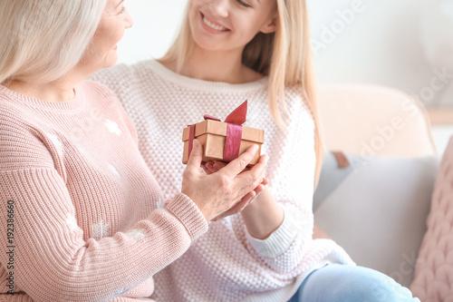 Young daughter giving gift ...
