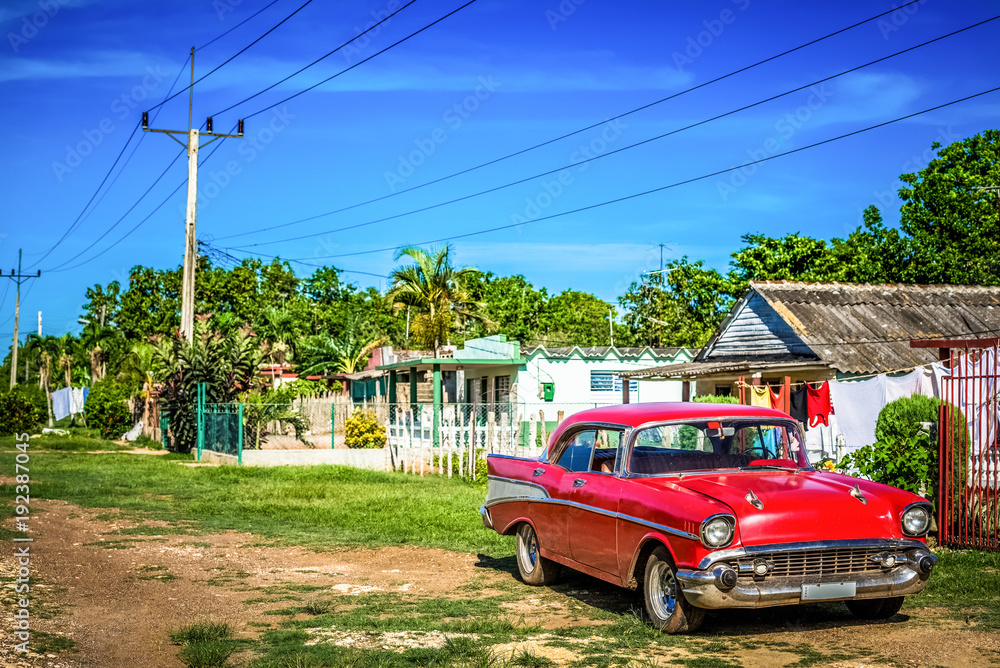 Roter amerikanischer Oldtimer parkt vor einem Haus im Landesinneren von Santa Clara Kuba - HDR - Serie Cuba Reportage 