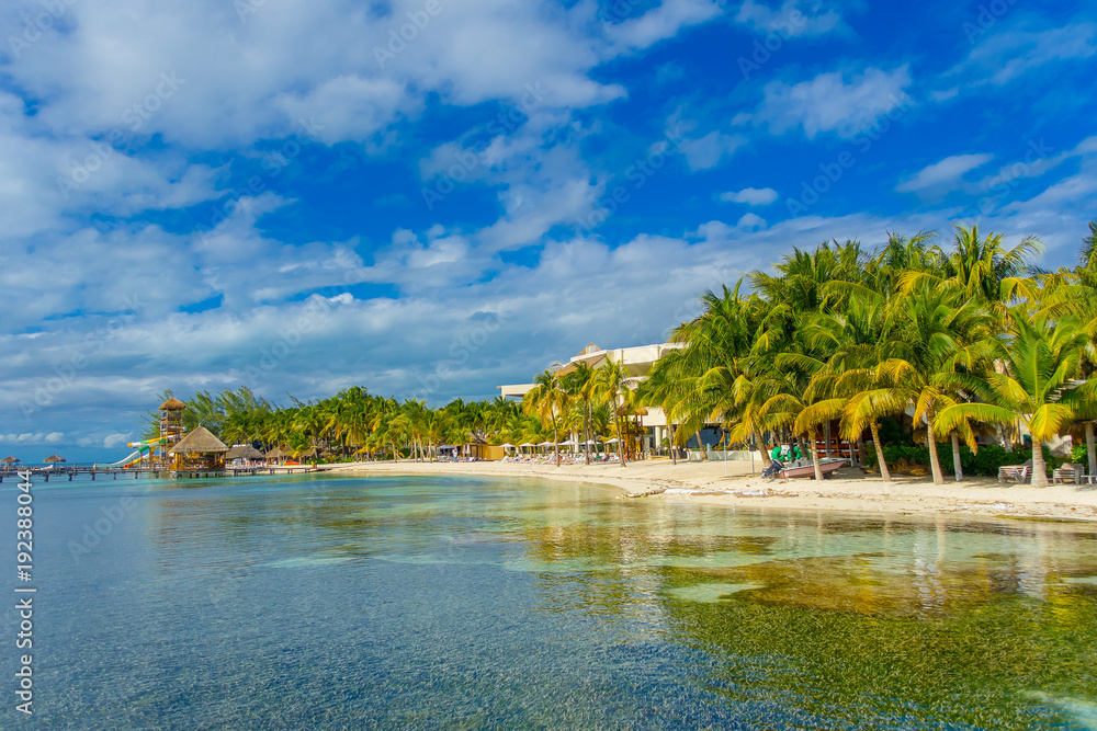 Astonishing beach with transparent water and white sand in the coasts of Isla mujeres in caribbean Beach in Mexico, paradise island, sun and palms. Tourism concept