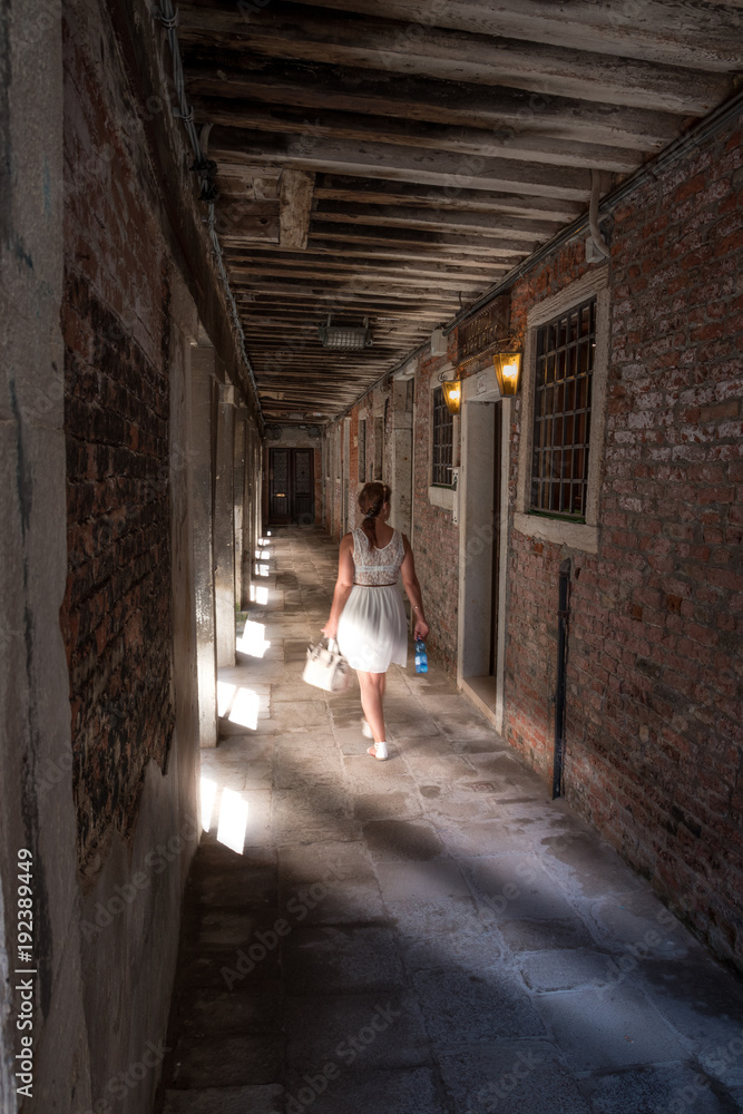 Touristin in Venedig in Italien geht durch Schatten in Gasse