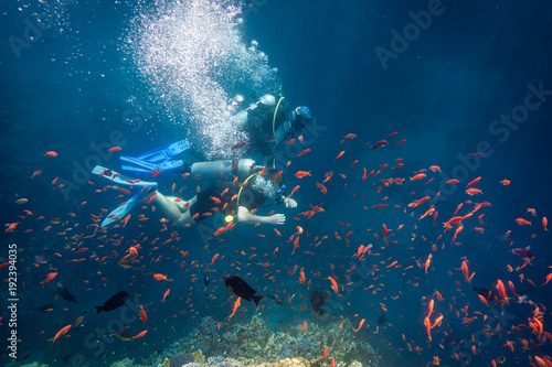 Scuba instructor diving with student near coral reef in Red sea 
