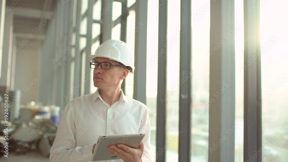 Chief Engineer in the Hard Hat Walks Through Light Modern Factory While Holding Laptop. Successful, Handsome Man in Modern Industrial Environment. 4 k Chief Engineer in the Hard Hat Walks Through Light Modern Factory While Holding Laptop. Successful, Handsome Man in Modern Industrial Environment. 4 k