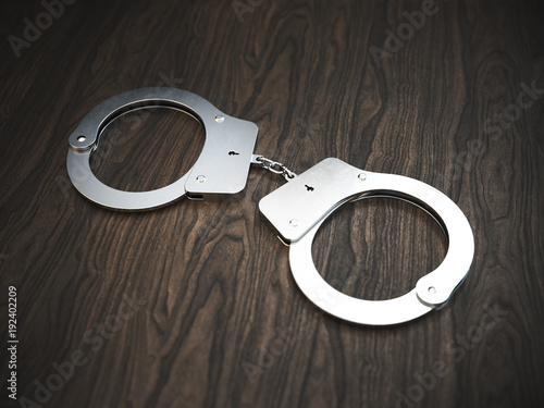 Handcuffs on wooden background