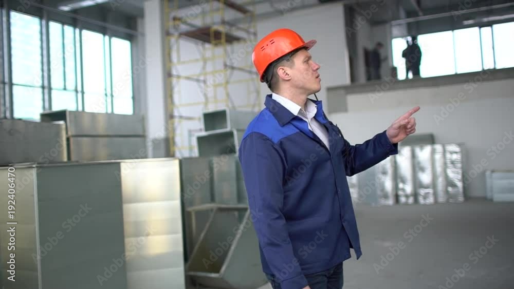 engineer worker builder foreman in factory construction site. People checks industrial air ducts of a ventilation system on clean and light technical floor. Air ducts for conditioning engineer worker builder foreman in factory construction site. People checks industrial air ducts of a ventilation system on clean and light technical floor. Air ducts for conditioning