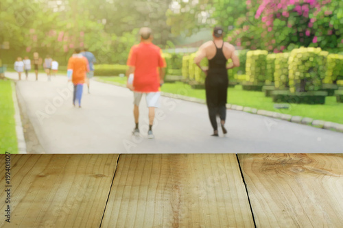 Wooden foreground with blurred public parks, People are jogging, Health and nature concept