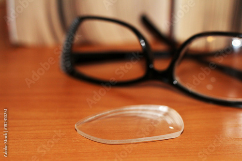 black frame glasses on wooden table, books background