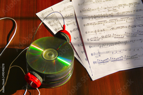 Stack of CDs with headphone and musical notes photo