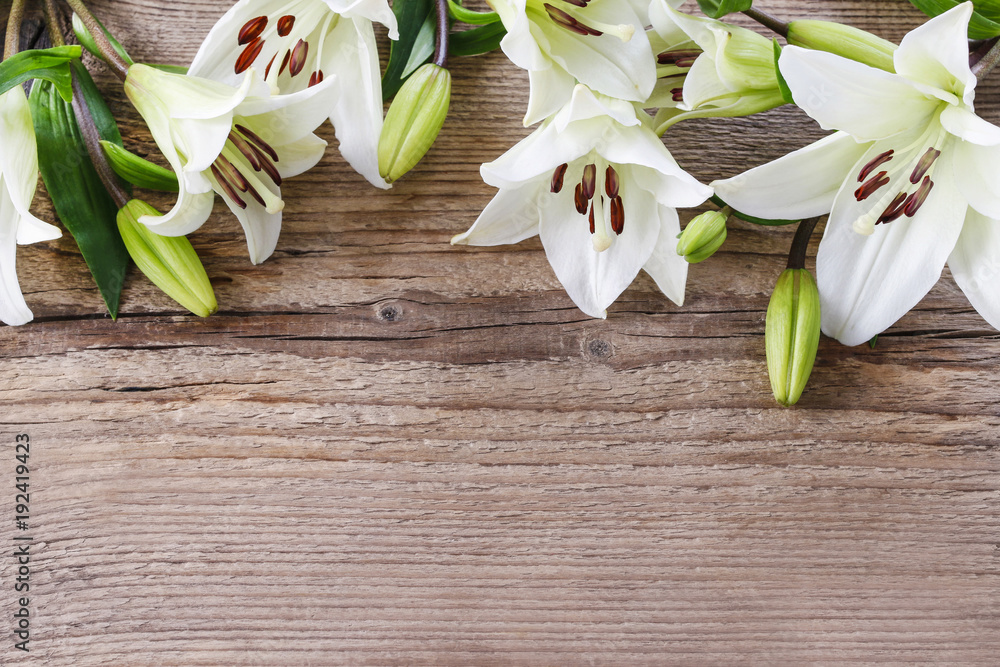 White lilies on wooden background White lilies on wooden background