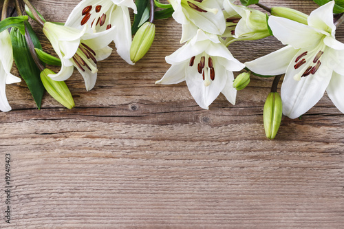 White lilies on wooden background