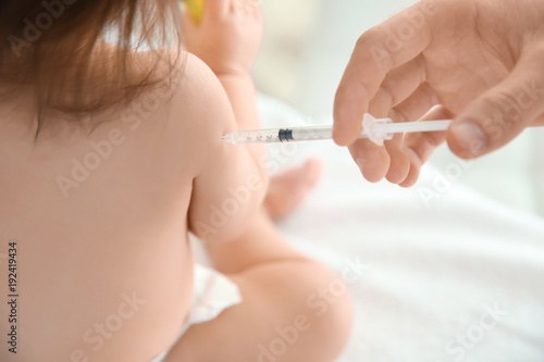 Doctor vaccinating baby girl, closeup