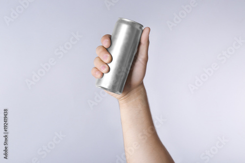 Fototapeta Naklejka Na Ścianę i Meble -  Male hand with aluminum can on light background
