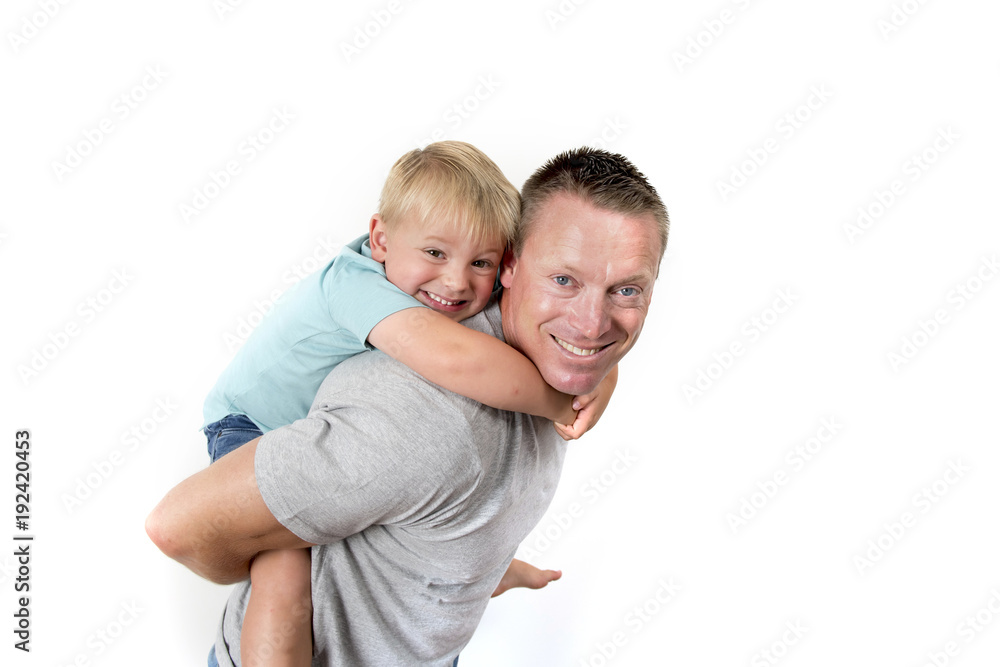 young attractive and athletic father carrying on his back young beautiful and blond son having fun together posing isolated on white background