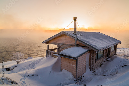 Wooden house on the beach in winter photo