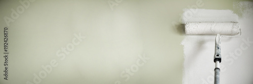 Hand painting wall with paint roller, pastel color. Appartment renovation, repair, building and home concept. Copy space, banner. Tools for painting walls.