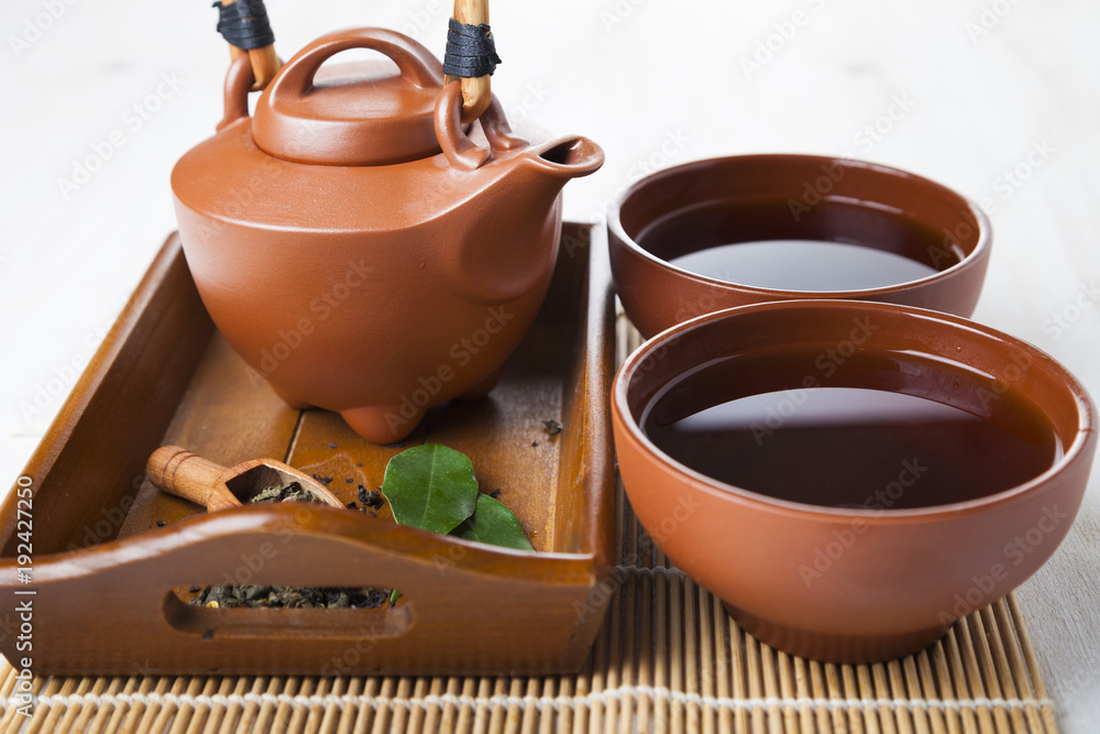 Ceramic teapot and tea leaves