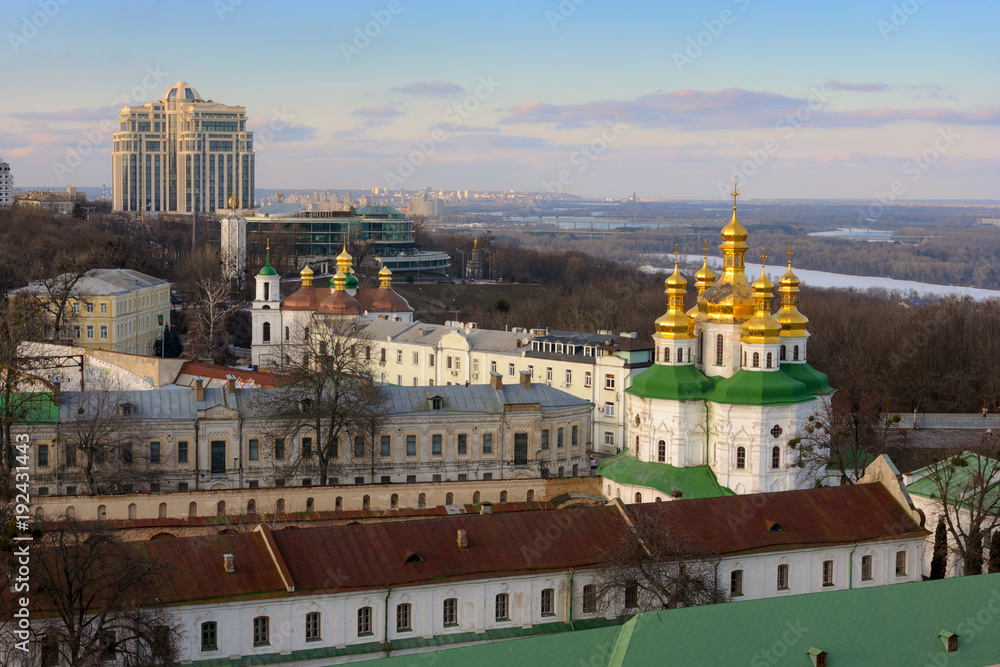 Kyiv landscape with Kiev Pechersk Lavra structures, modern buildings and Dnieper river on background.