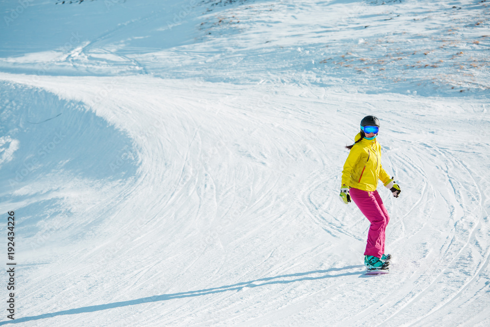 Image of sports woman snowboarding from mountain slope