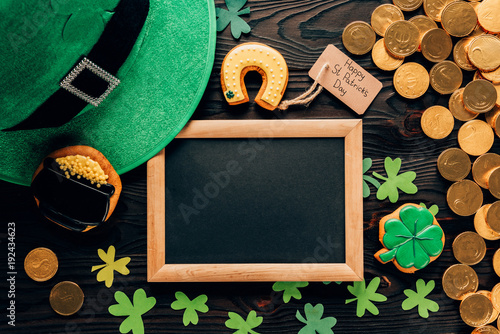 Fototapeta Naklejka Na Ścianę i Meble -  top view of empty board with gingerbread and shamrock on table, st patricks day concept