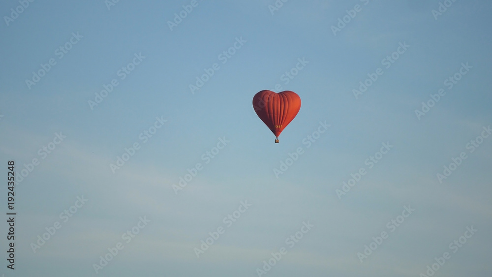 Fototapeta premium Hot air balloon shape of a heart in the blue sky. Aerostat, Airship. Red balloon.