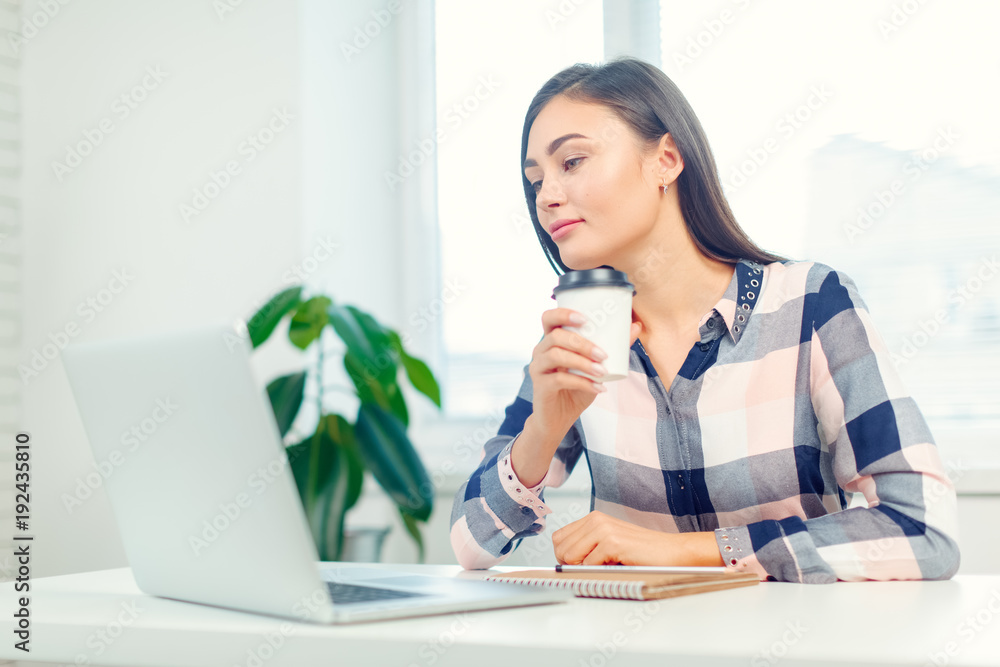 Happy smiling woman working with laptop and drinking coffee Happy smiling woman working with laptop and drinking coffee