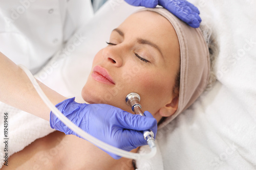 Peeling tlenowy. Kobieta w salonie kosmetycznym podczas zabiegu pielęgnacyjnego photo