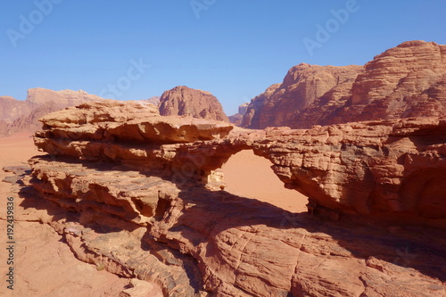 Natural rock bridge and panoramic view of Jordanian desert Wadi Rum