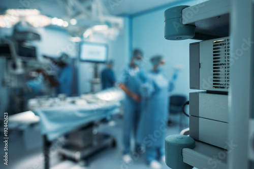 doctor helping to wear surgical uniform on blurred background