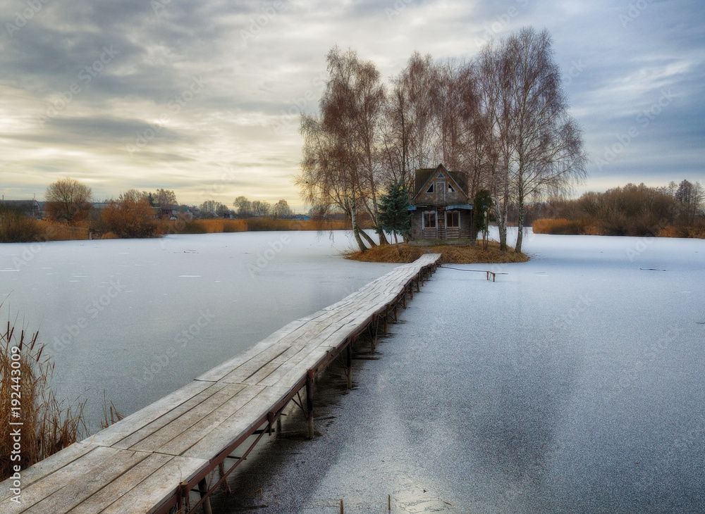 House on the island. Bridge on a river to a picturesque hut