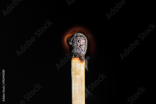 The match is almost completely extinguished on black background closeup
