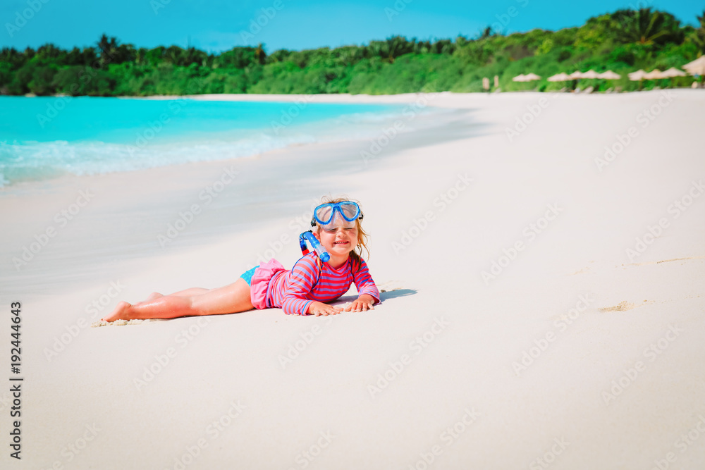 cute little girl snorkeling on beach