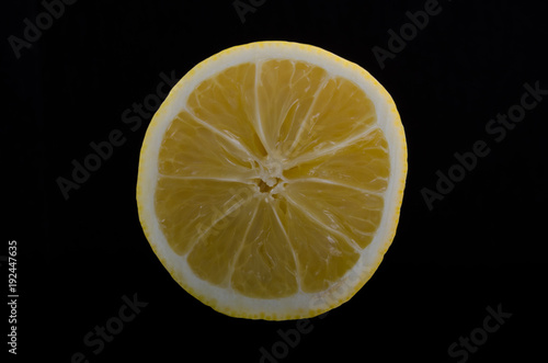 Cut yellow lemon isolated on a black background
