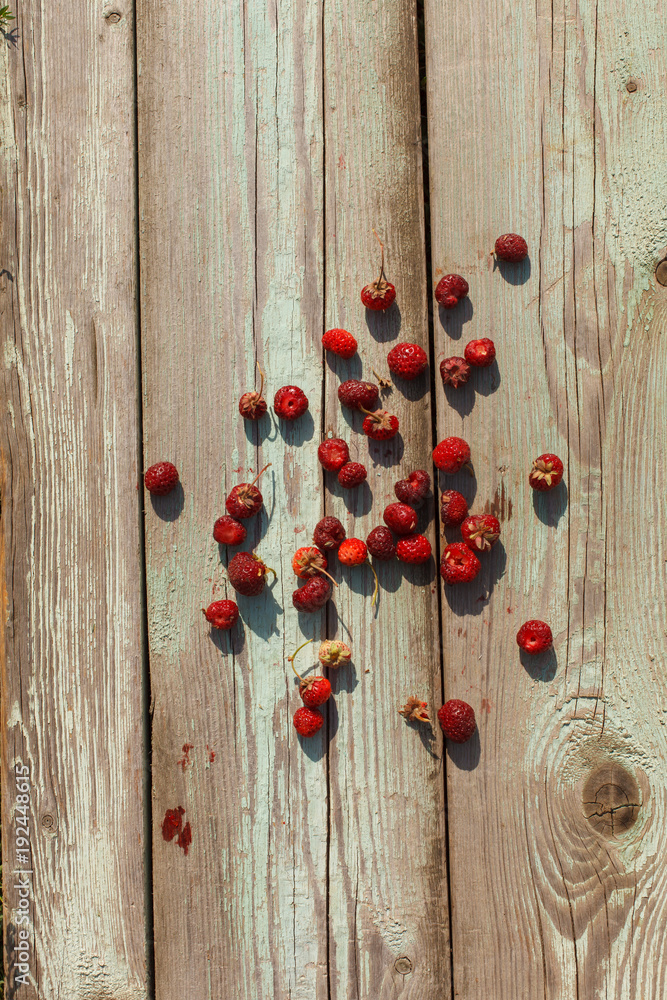 Top view of red raspberries and black currant on old wooden table