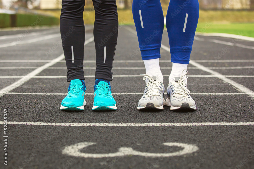 Front cropped view of two runners in running shoes. Front cropped view of two runners in running shoes.
