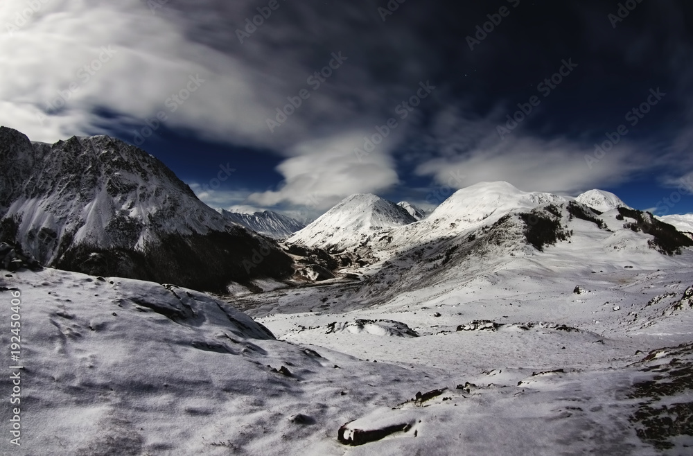 Fototapeta premium Winter night mountain frozen river valley with ranges of snow peaks under moon light Altai Mountains Siberia Russia