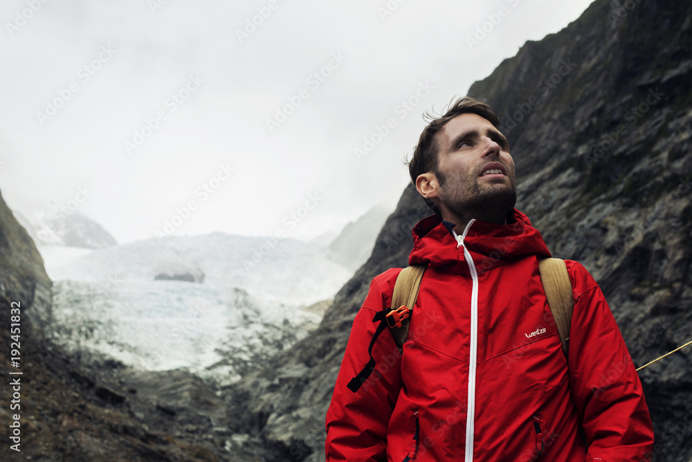 Retrato de hombre joven frente a glaciar entre montañas en la Isla Sur de Nueva Zelanda Retrato de hombre joven frente a glaciar entre montañas en la Isla Sur de Nueva Zelanda