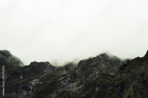 Paisaje de picos de montañas verdes con cielo nublado en Nueva Zelanda