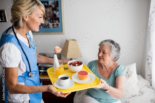 Nurse giving food to a senior woman