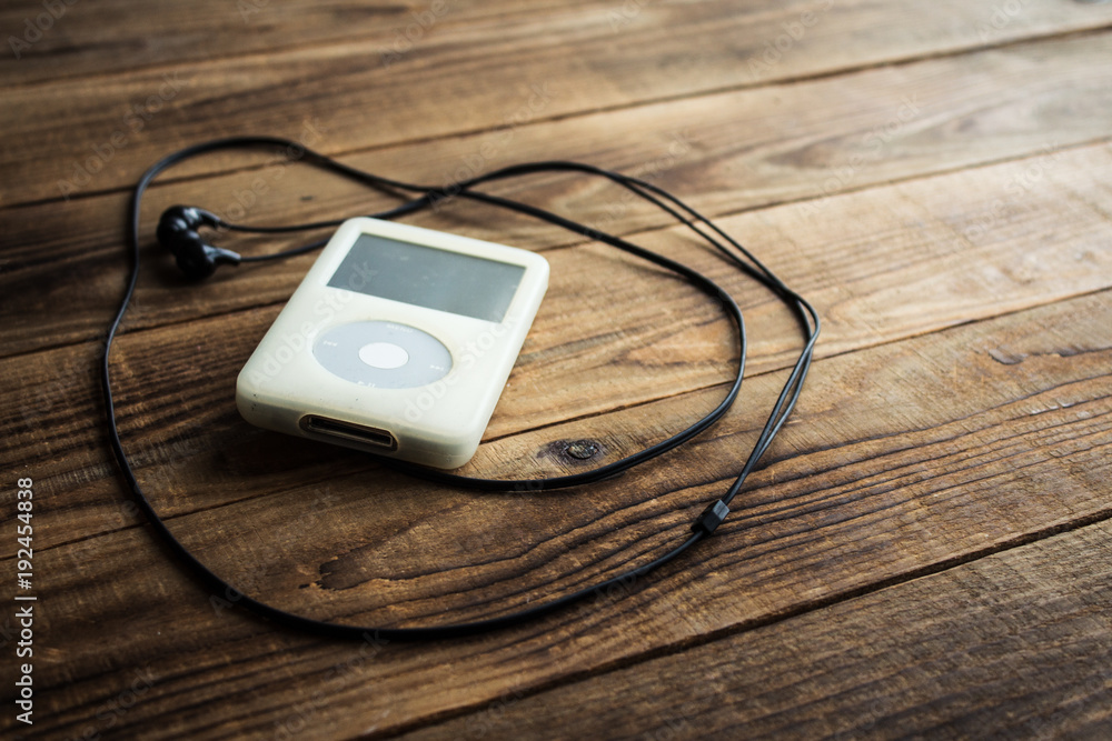 Music player and earphones on a wooden background Music player and earphones on a wooden background