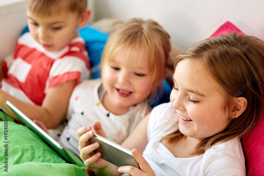 little kids with smartphone in bed at home little kids with smartphone in bed at home