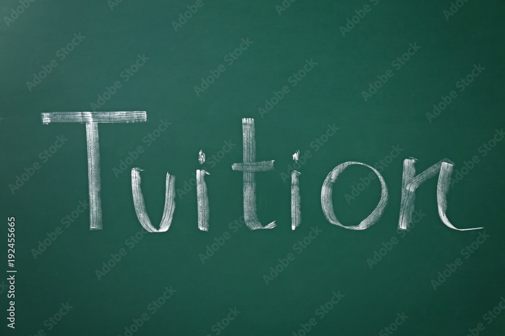 Word TUITION written on chalkboard Word TUITION written on chalkboard
