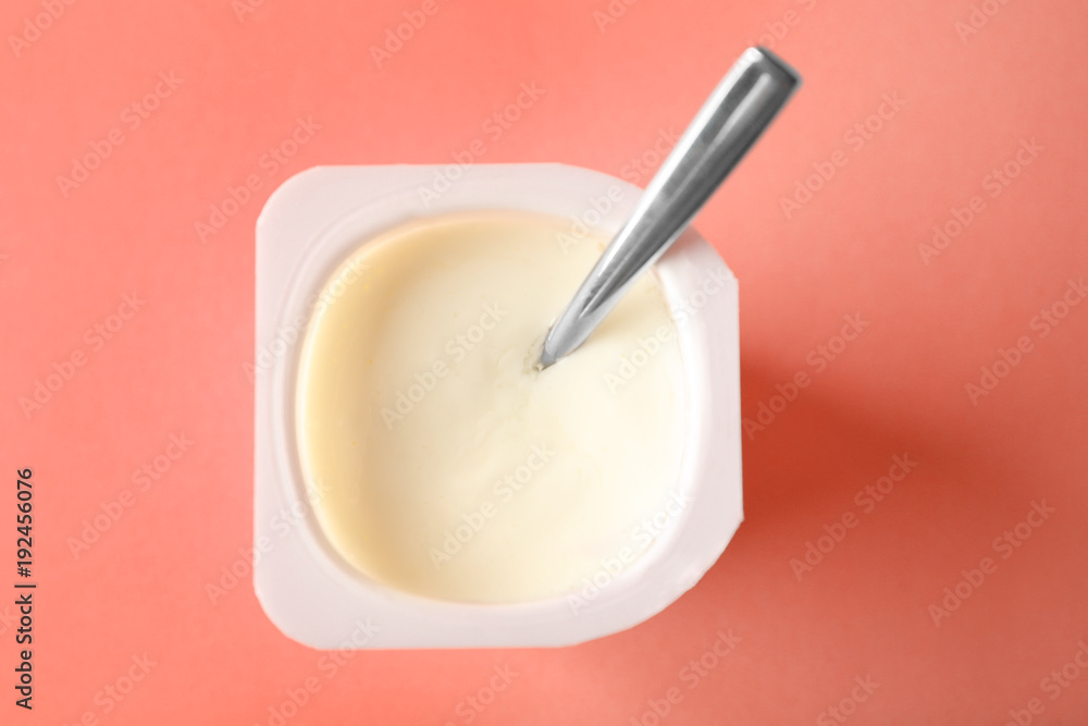 Plastic cup with yummy yogurt on color background Plastic cup with yummy yogurt on color background
