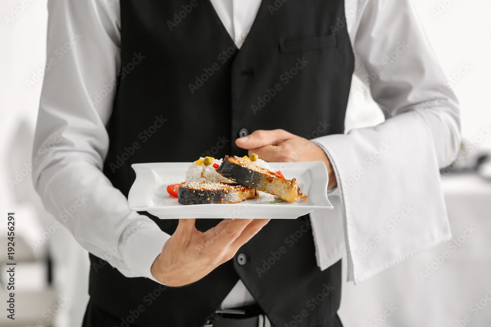 Waiter holding plate with fish and rice, closeup