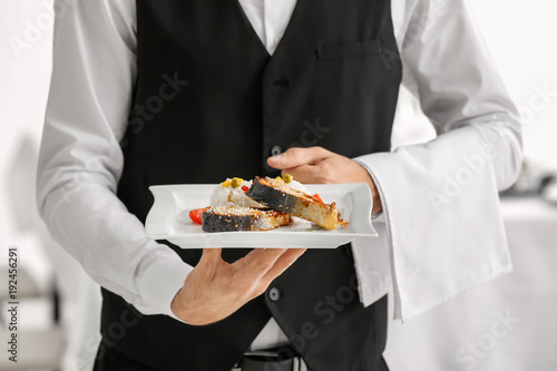 Waiter holding plate with fish and rice, closeup © Africa Studio