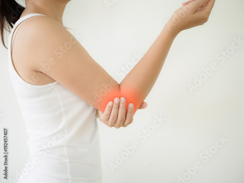 Close up woman having pain in injured elbow. Health care and arm pain concept.